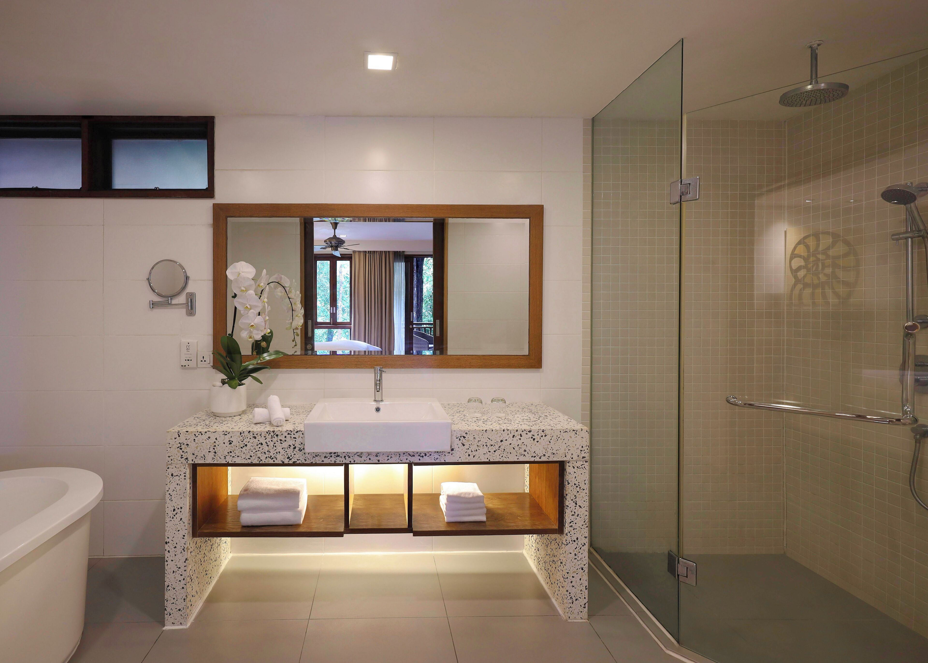 Un baño moderno con un espejo grande, un lavabo, una ducha y una bañera.