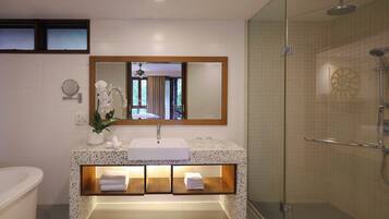 Un baño moderno con un espejo grande, un lavabo, una ducha y una bañera.