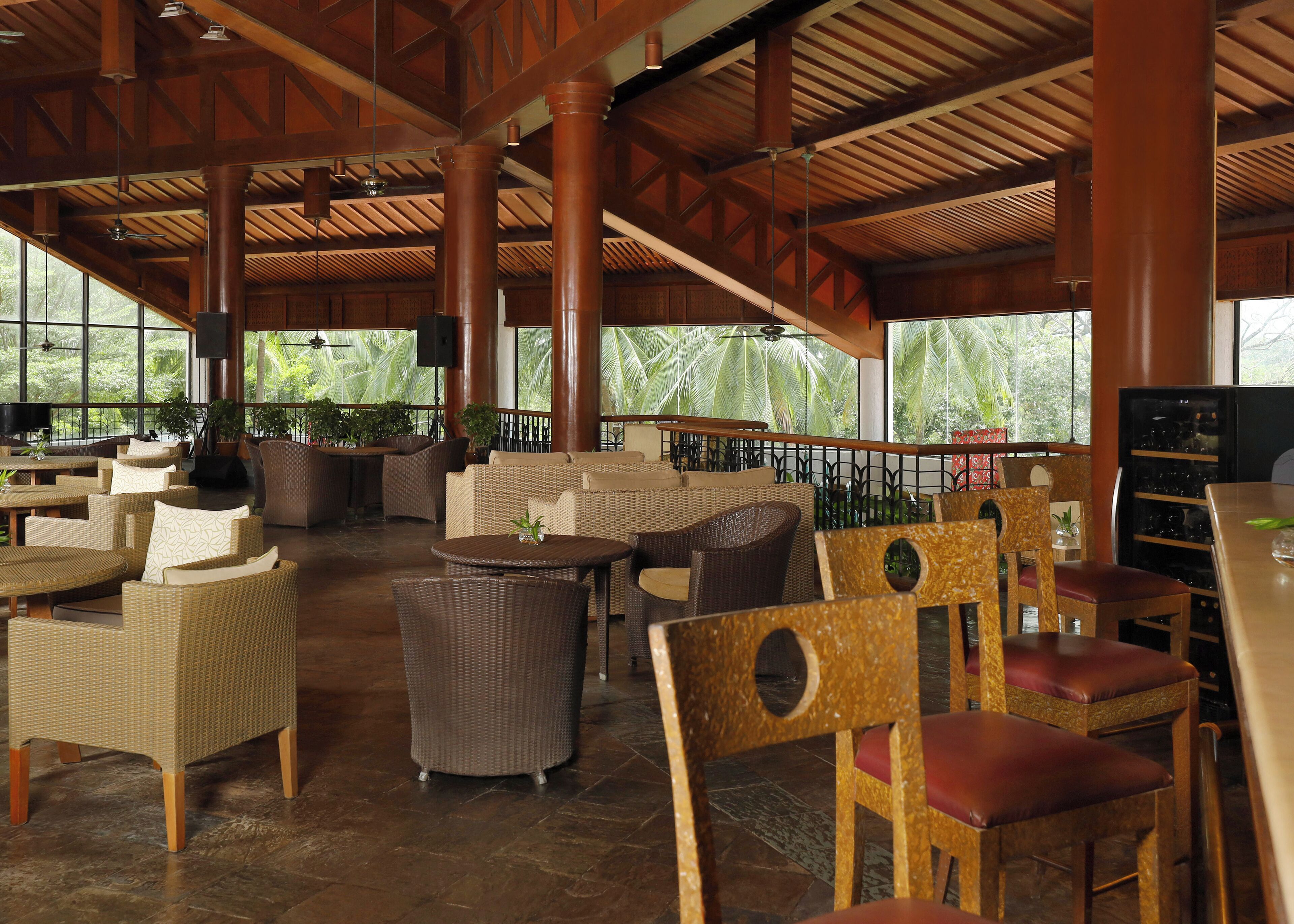 A spacious outdoor seating area with wicker furniture and a wooden ceiling.