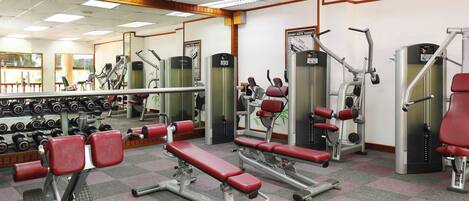 A gym with various exercise equipment, including treadmills, weight machines, and dumbbells.
