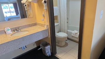 A hotel bathroom with a sink, toilet, and shower.