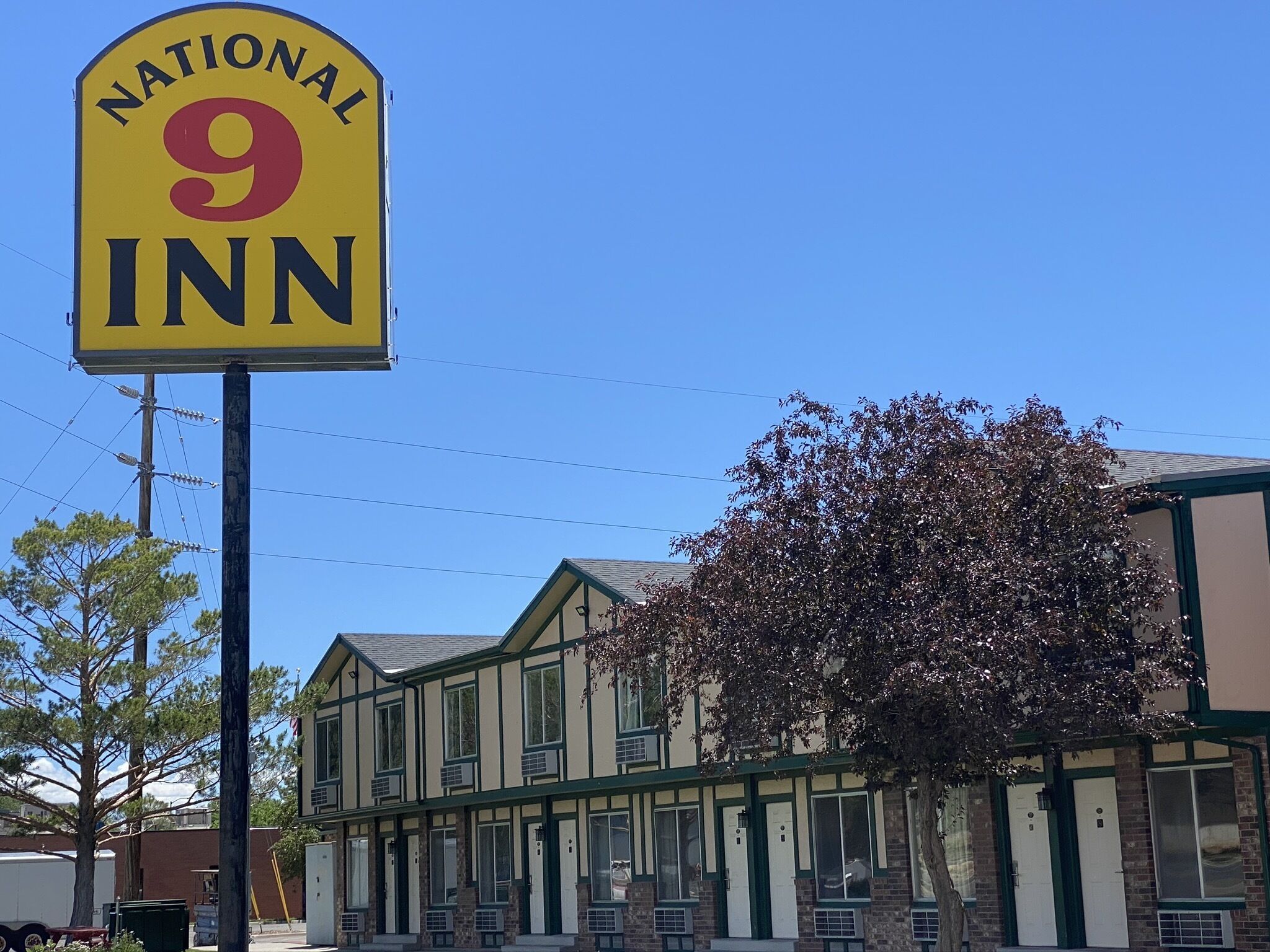 Señal de National 9 Inn con un edificio al fondo.