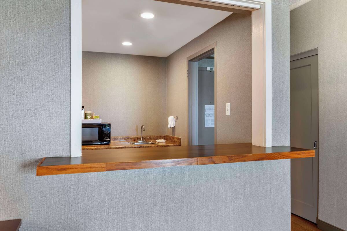 A modern bathroom with a wooden vanity, a sink, and a mirror.