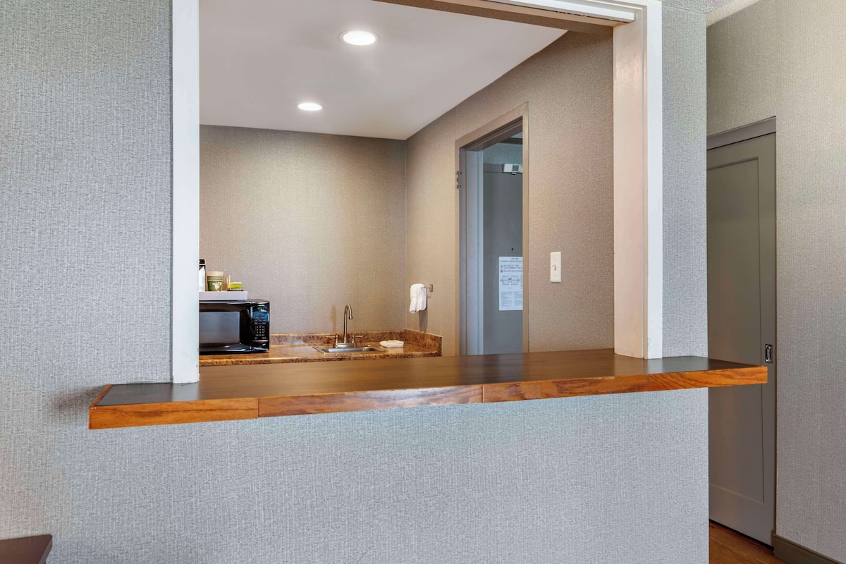 A modern bathroom with a wooden vanity, a sink, and a mirror.
