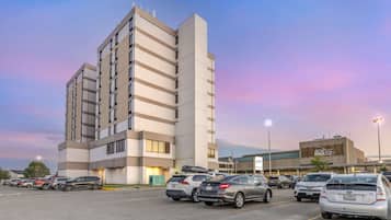 Un estacionamiento con varios autos y un edificio moderno con un letrero que dice "BCRV".