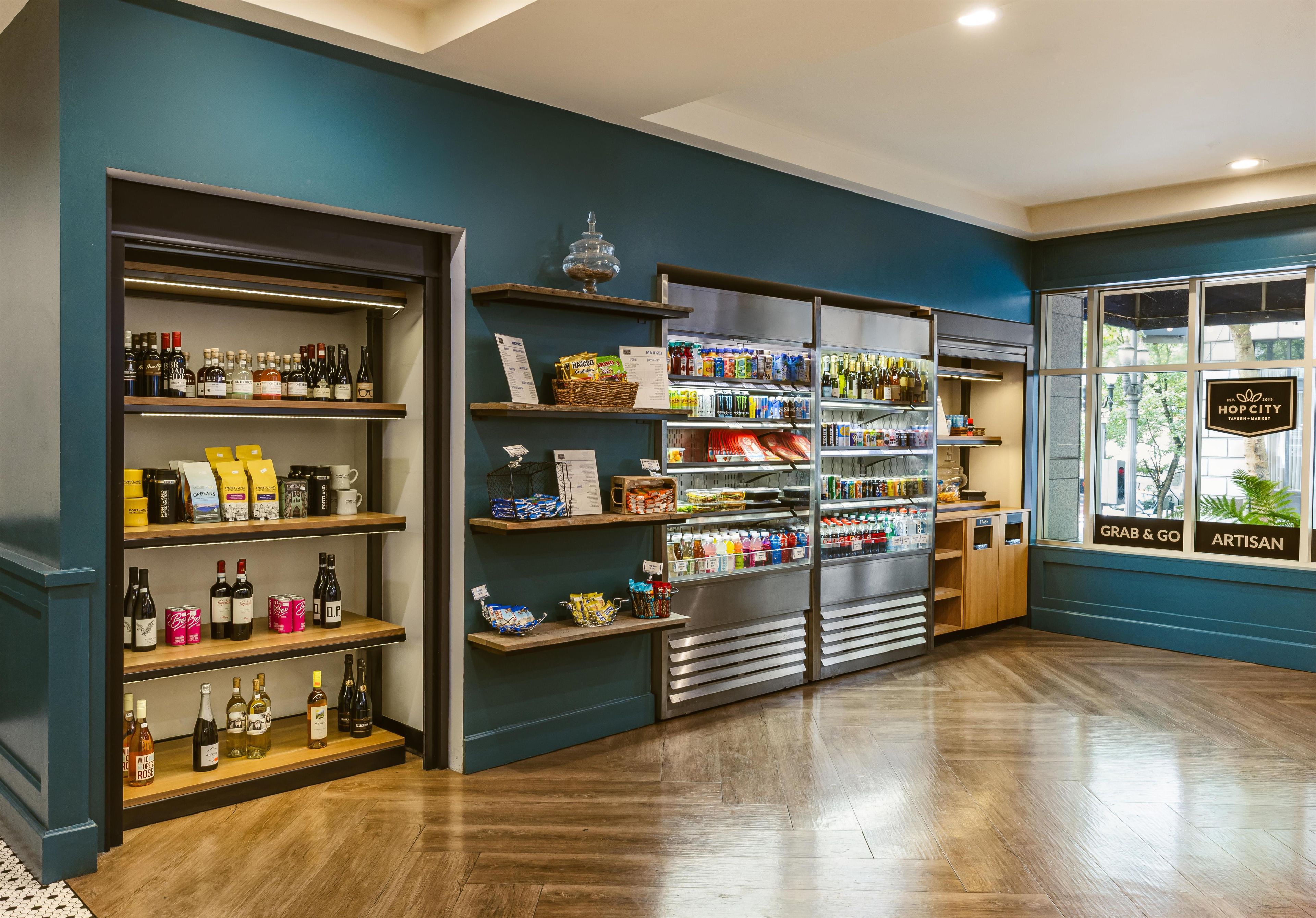 A store with shelves of beverages, a sign reading 'GRAB & GO,' and a window with 'ARTISAN' signage.