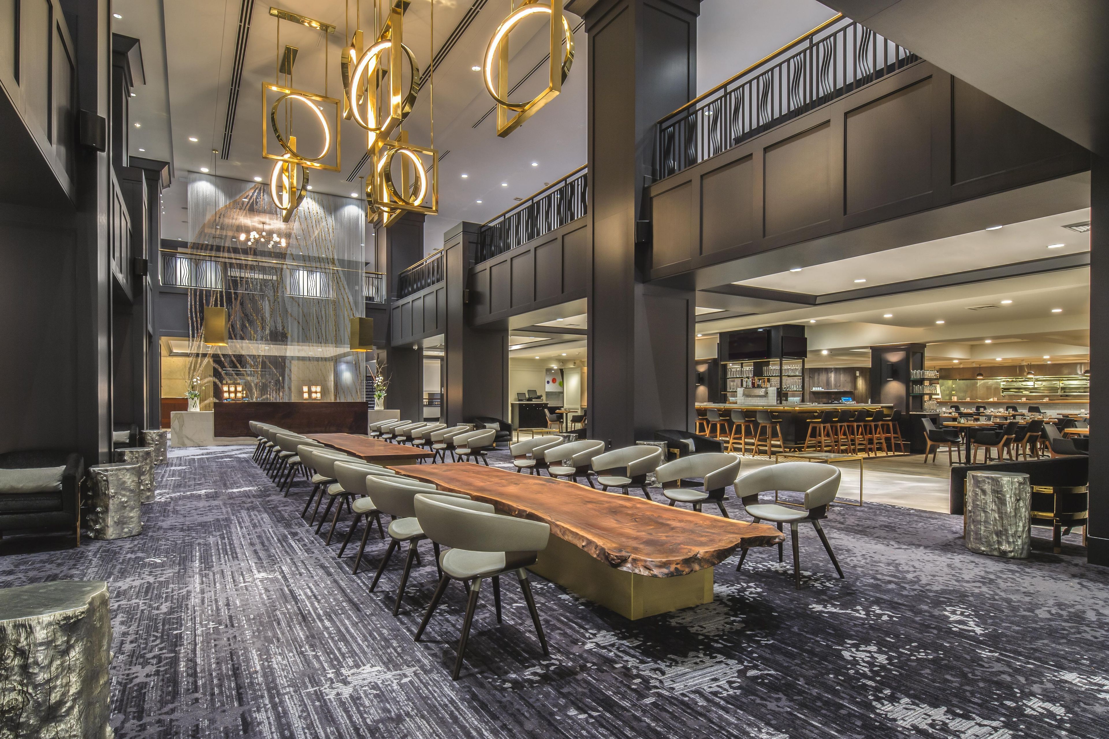 Un salón de conferencias con una larga mesa y sillas, una zona de bar y una escalera.