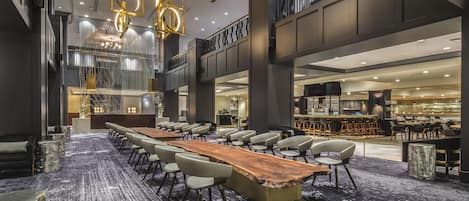 Un salón de conferencias con una larga mesa y sillas, una zona de bar y una escalera.