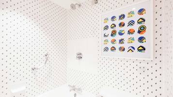 A bathroom with a shower, a sink, and a wall-mounted toilet.