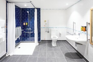 A modern bathroom with a shower, toilet, and sink.