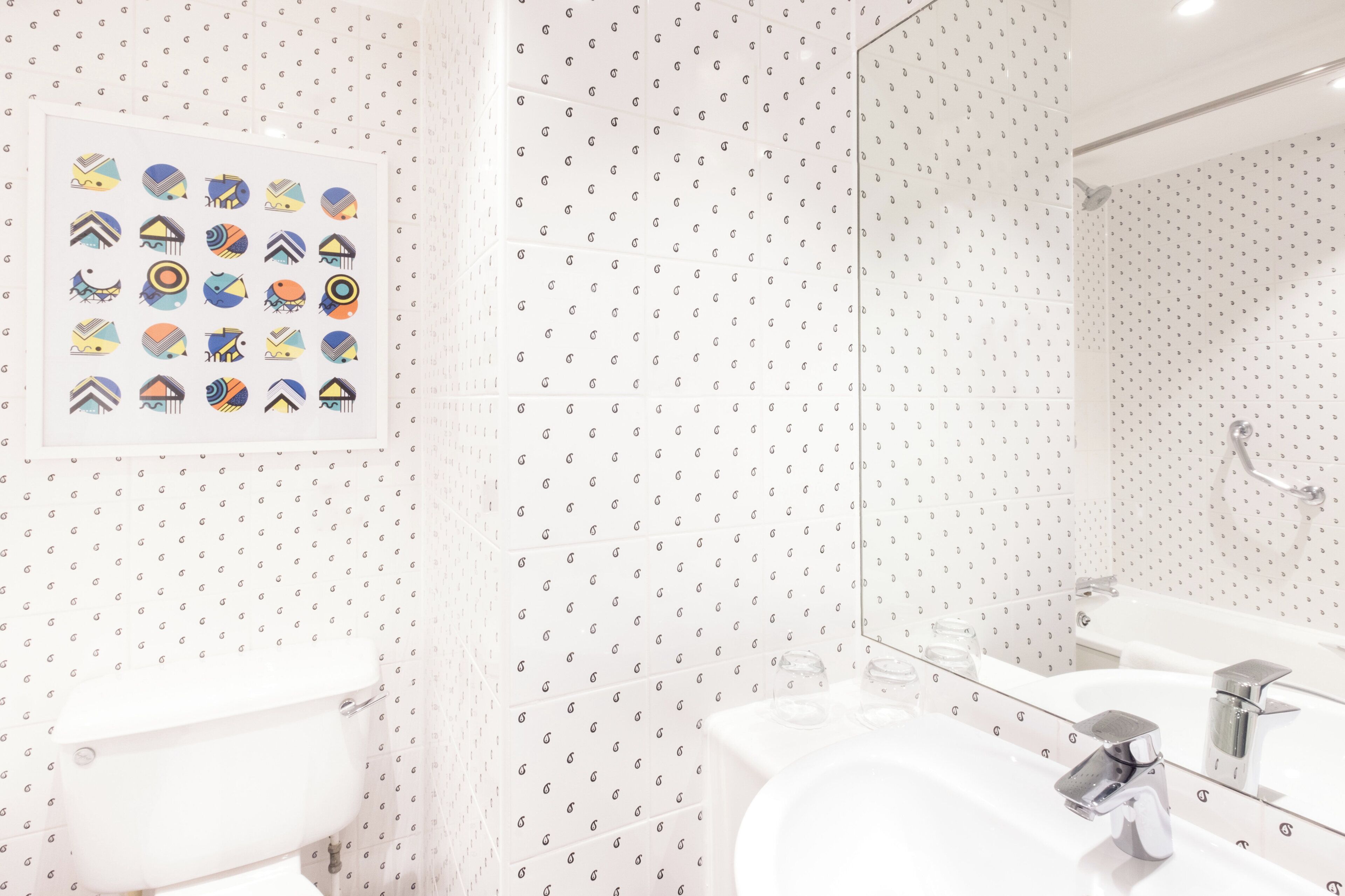 Une salle de bain avec des toilettes, un lavabo et un miroir.