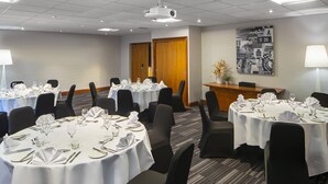 A conference room with multiple round tables set for dining, equipped with chairs, tablecloths, and dining utensils. - Holiday Inn Coventry M6, Jct.2 by IHG (Coventry)