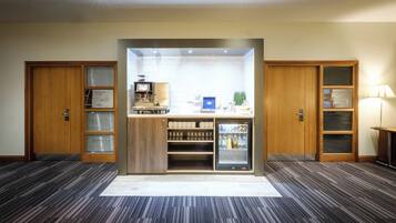 Una habitación de hotel con minibar, cafetera y refrigerador.