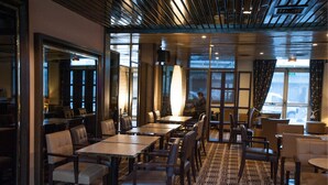 A modern restaurant with high ceilings, large windows, and a patterned carpet. - Median Paris Congres Hotel (Paris)
