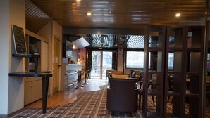 A modern interior with a kitchen area, bar seating, and a patterned carpet. - Median Paris Congres Hotel (Paris)
