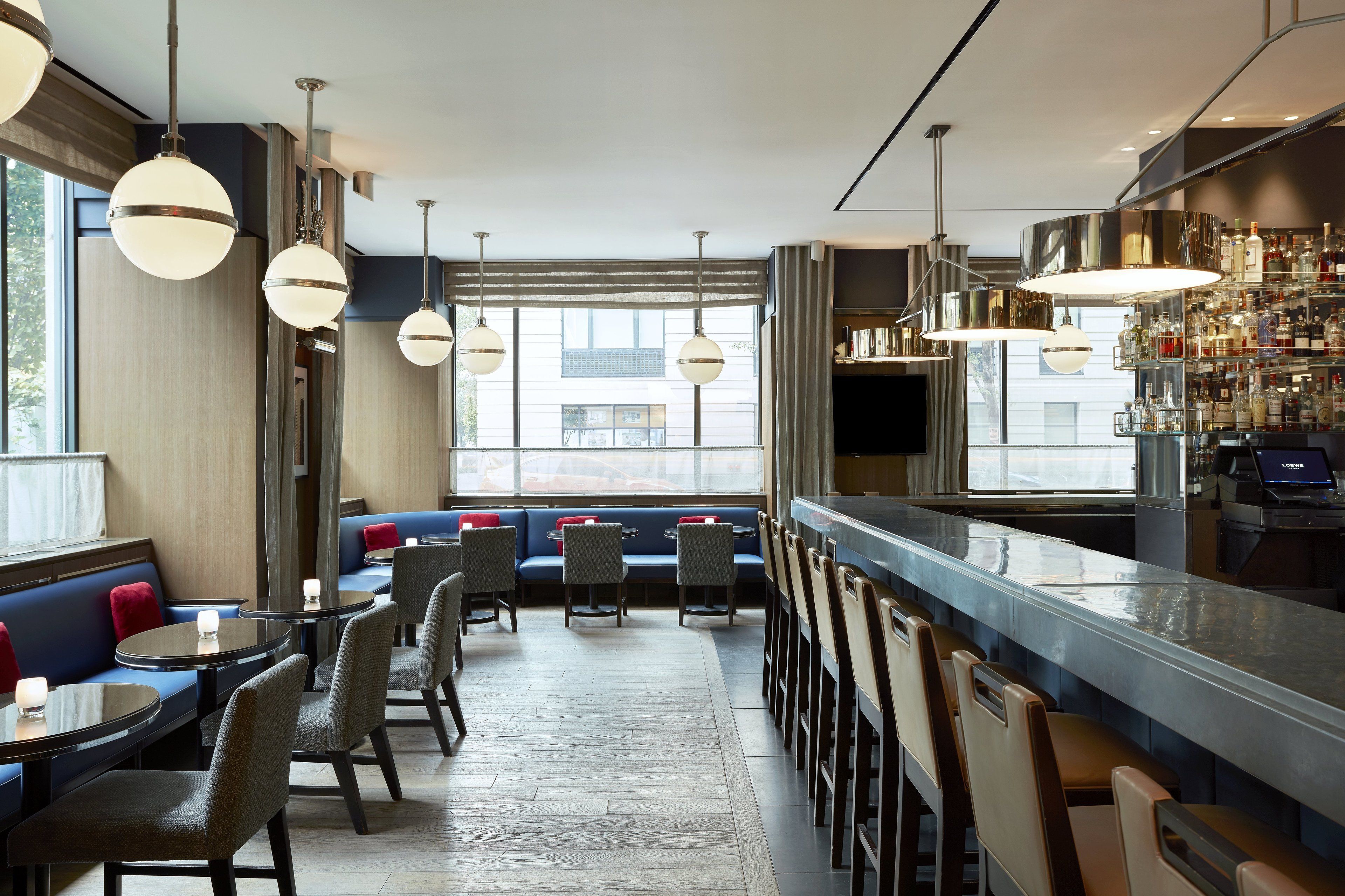 Eine moderne Bar mit Sitzgelegenheiten, großen Fenstern und einer gut sortierten Bar.