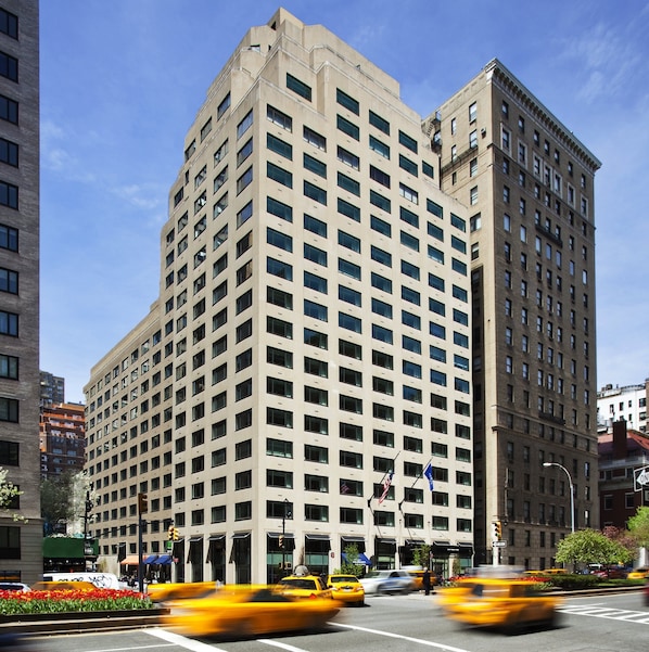 Um edifício alto e moderno, com uma fachada em grade de janelas e telhado plano.