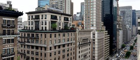 A cityscape with tall buildings, a busy street with vehicles, and a clear sky.