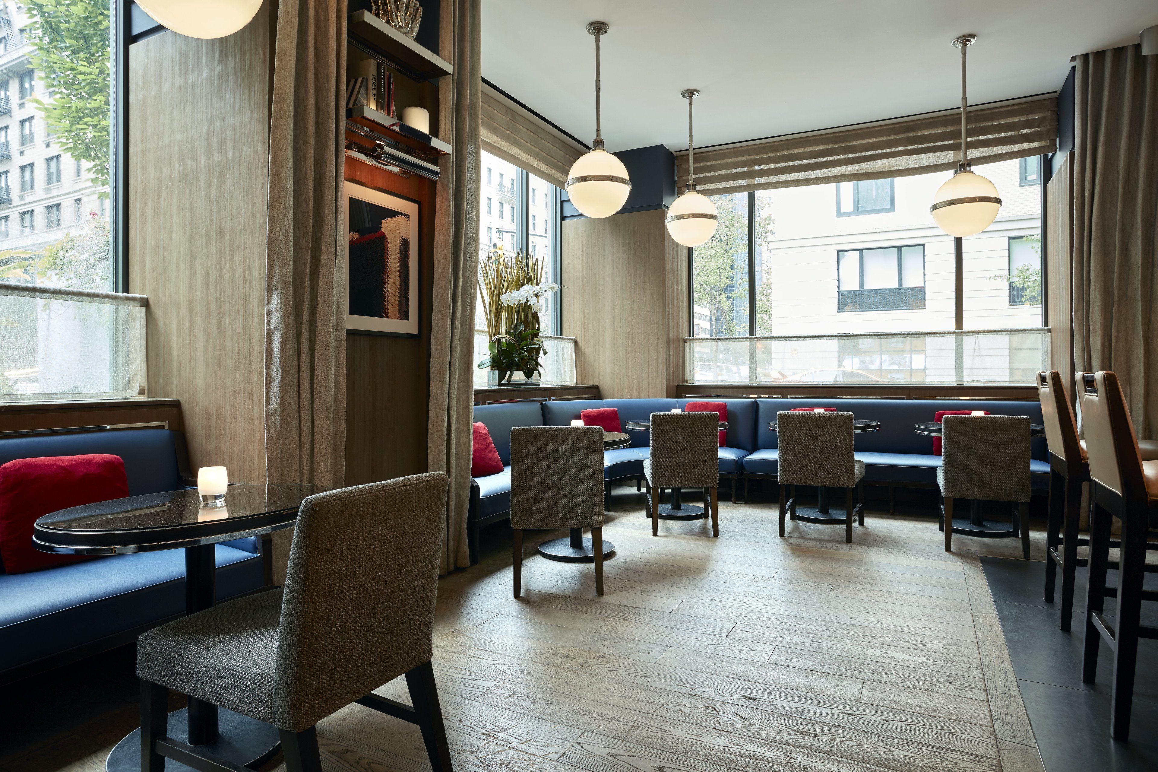 Un interior moderno con una zona de estar, una mesa y lámparas colgantes.
