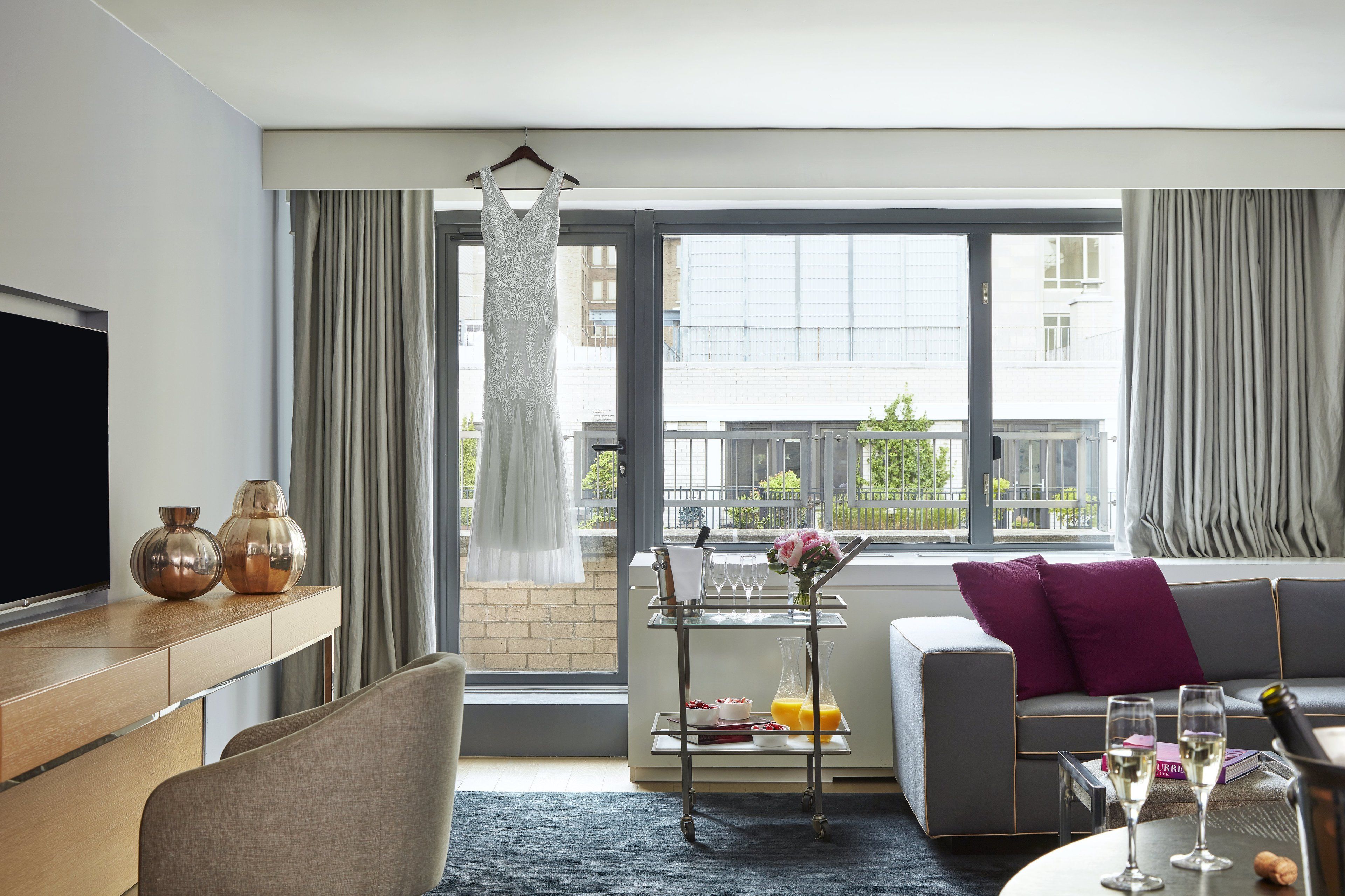 Ein modernes Wohnzimmer mit Sofa, Fernseher und einer Essecke mit Servierwagen.