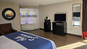 A hotel room with a bed, a TV, a microwave, and a bathroom with a jacuzzi. - Days Inn by Wyndham Easley/Greenville/Clemson Area (Easley)