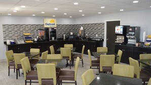 A Daybreak breakfast restaurant with multiple tables and chairs, a coffee machine, and a refrigerator. - Days Inn by Wyndham Easley/Greenville/Clemson Area (Easley)