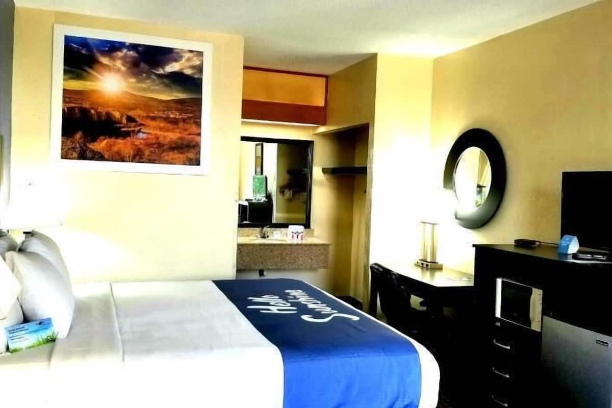 Escritorio, cortinas blackout y tabla de planchar con plancha