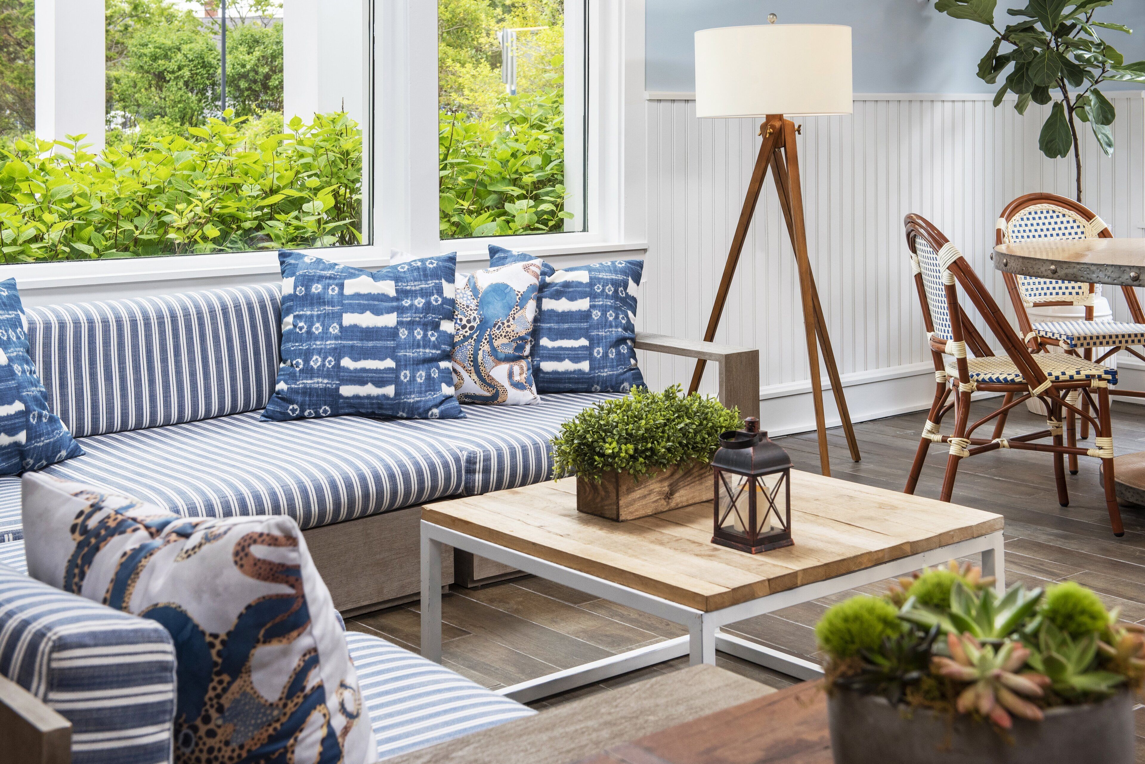 A cozy living room with a striped sofa, wooden coffee table, and wicker chairs.