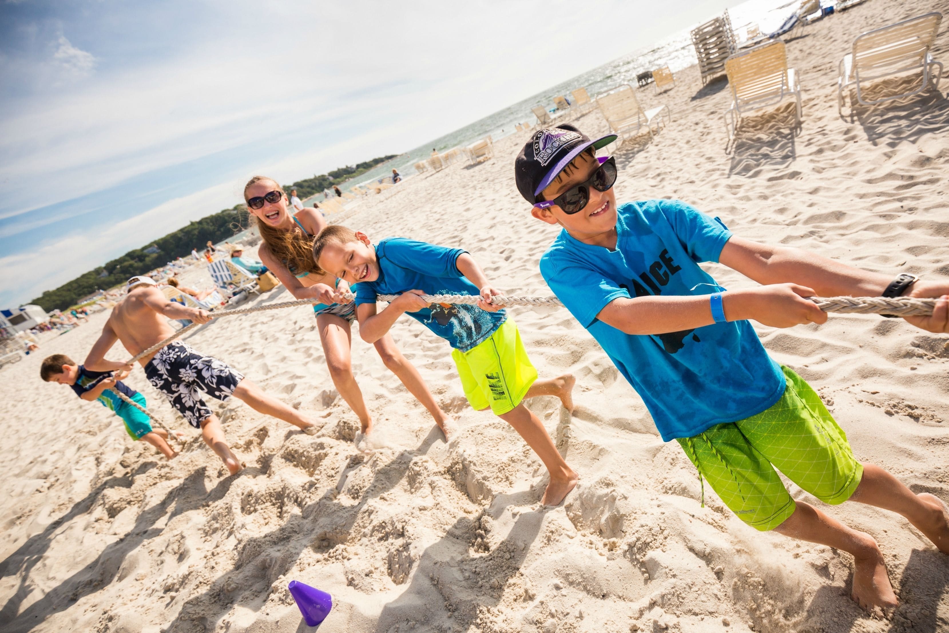 Uma praia arenosa com pessoas jogando.