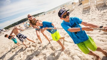 Uma praia arenosa com pessoas jogando.