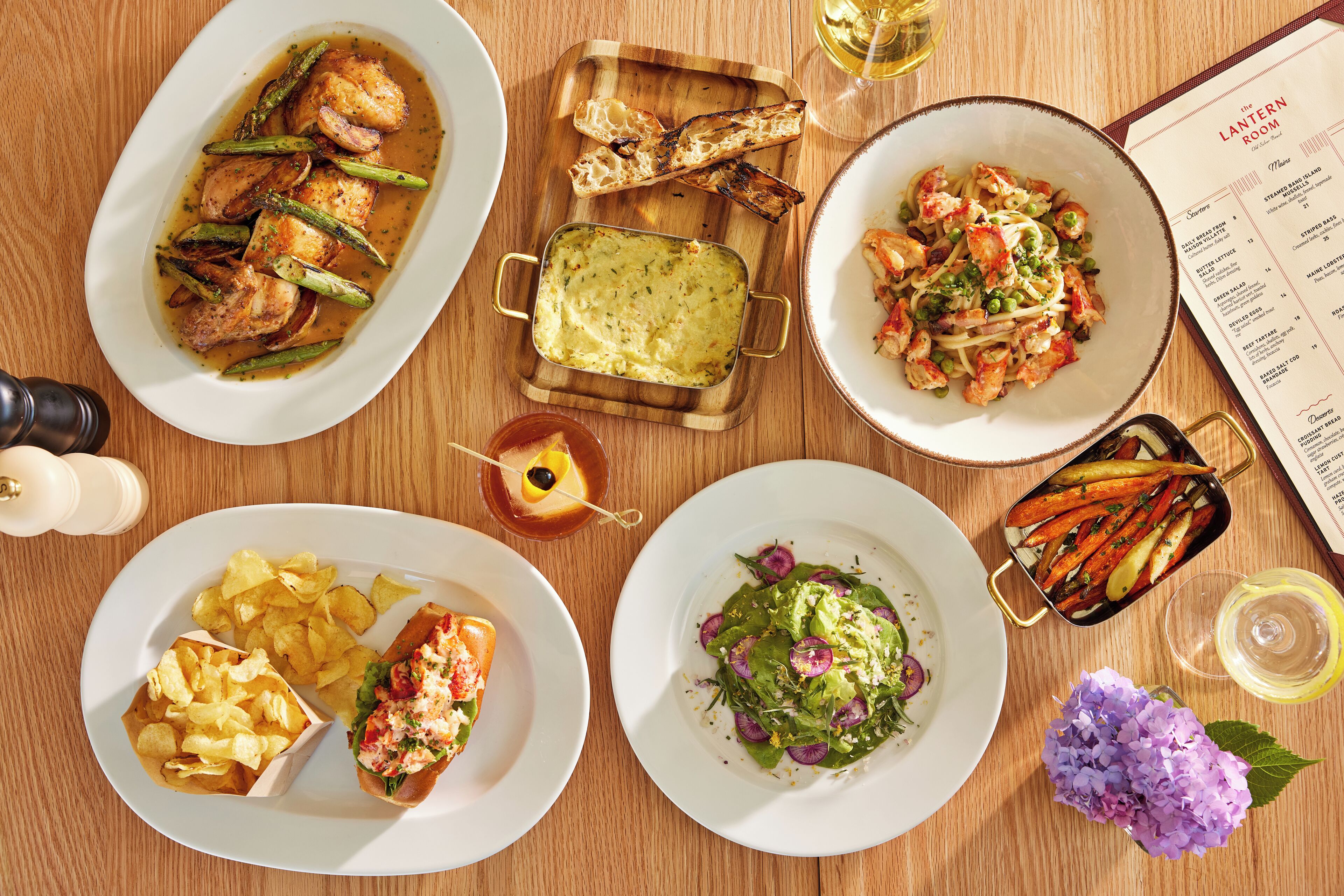A variety of dishes including seafood, vegetables, and bread on a wooden table.