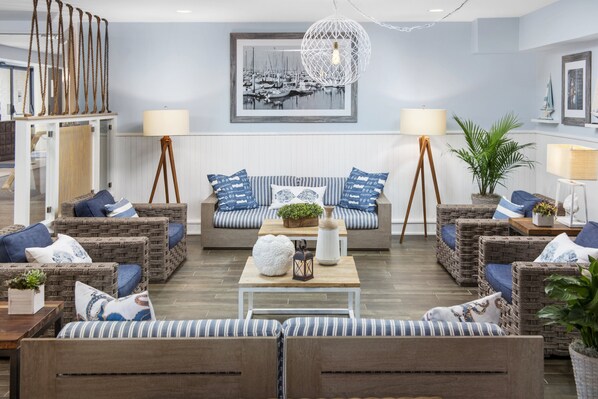A cozy living room with wicker furniture, a wooden coffee table, and a framed picture on the wall.