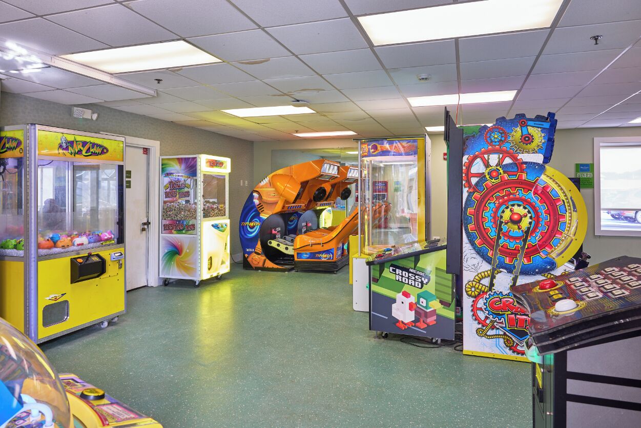 An indoor arcade with various claw machines and a large, colorful game titled "CRASH IT".