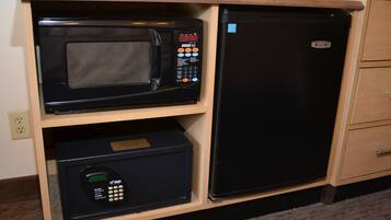 A kitchen with a microwave and a refrigerator built into a wooden cabinet.