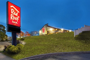 Ett Red Roof Inn-hotell med en modern byggnad och en stor, upplyst skylt.