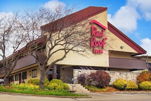 En byggnad med ett rött tak och en skylt med texten ”Red Roof Inn”.