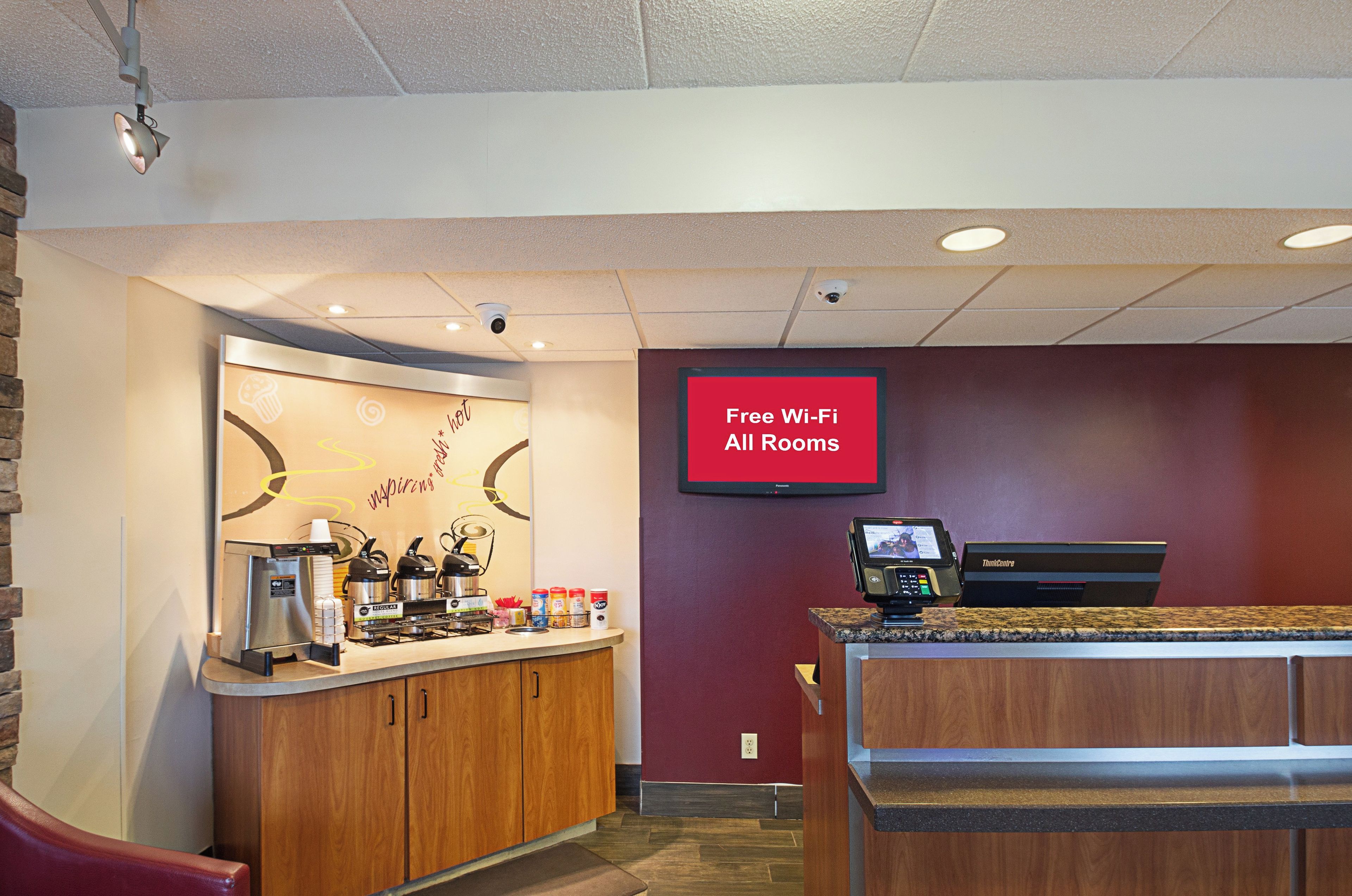 A cafe area with a coffee machine, a cash register, and a sign indicating free Wi-Fi availability.