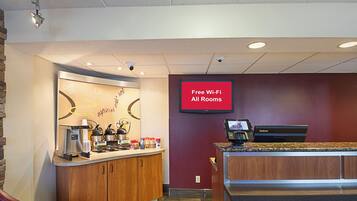 A cafe area with a coffee machine, a cash register, and a sign indicating free Wi-Fi availability.
