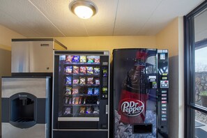 A vending machine area with a Dr Pepper dispenser and a snack vending machine. - Red Roof Inn Madison, WI (Madison)