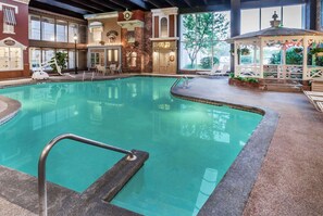 An indoor swimming pool with a stone border, a gazebo, and a view of the outside. - Wyndham Garden Warsaw (Warsaw)