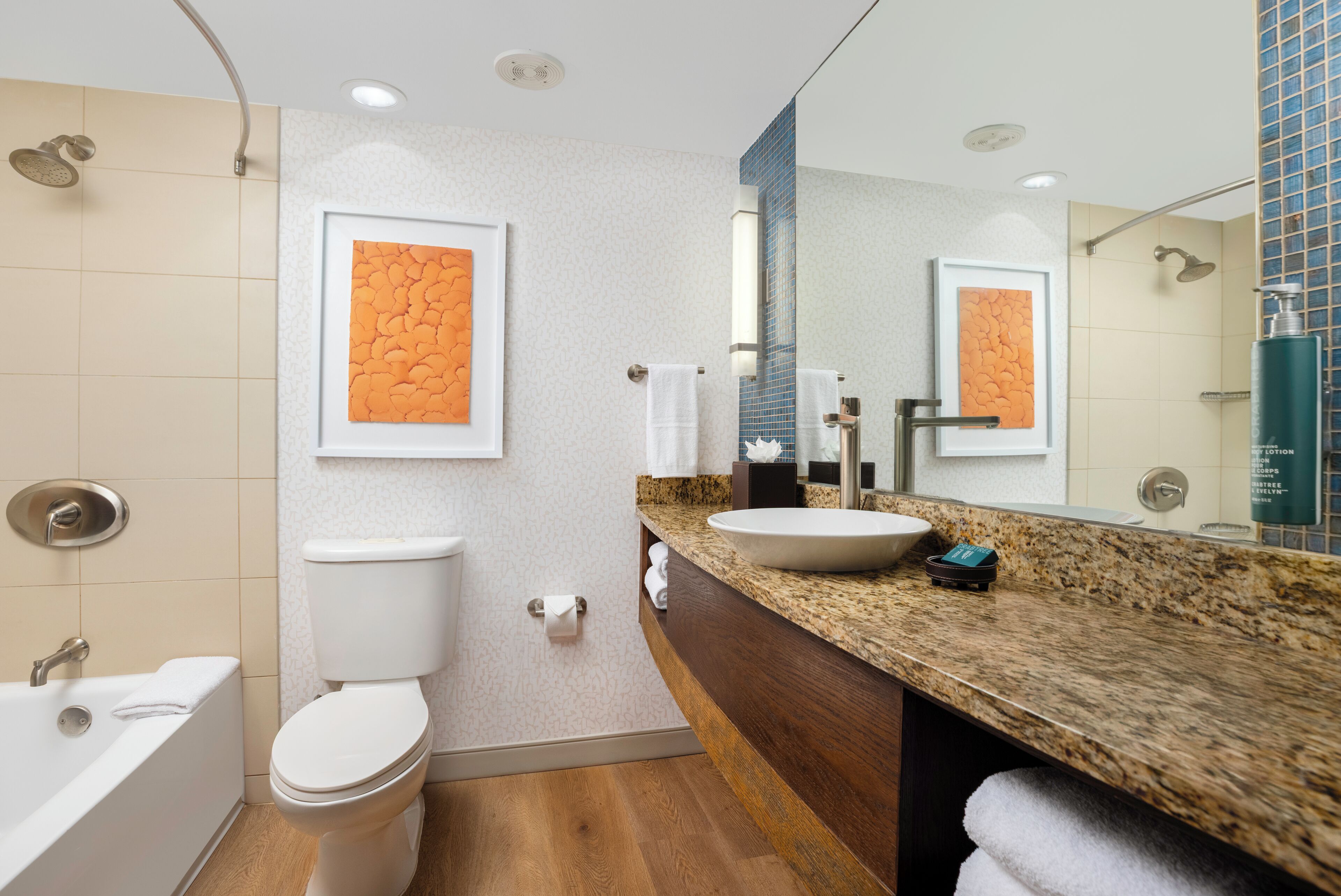 A modern bathroom with a toilet, sink, and bathtub.