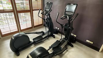 Une salle de sport équipée de deux appareils elliptiques, d’un tapis de course et d’un vélo d’appartement.