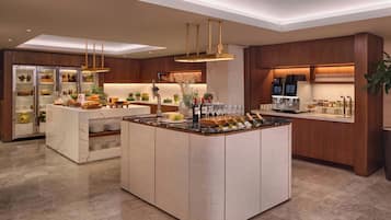 A modern kitchen with a central island, built-in appliances, and a bar area.