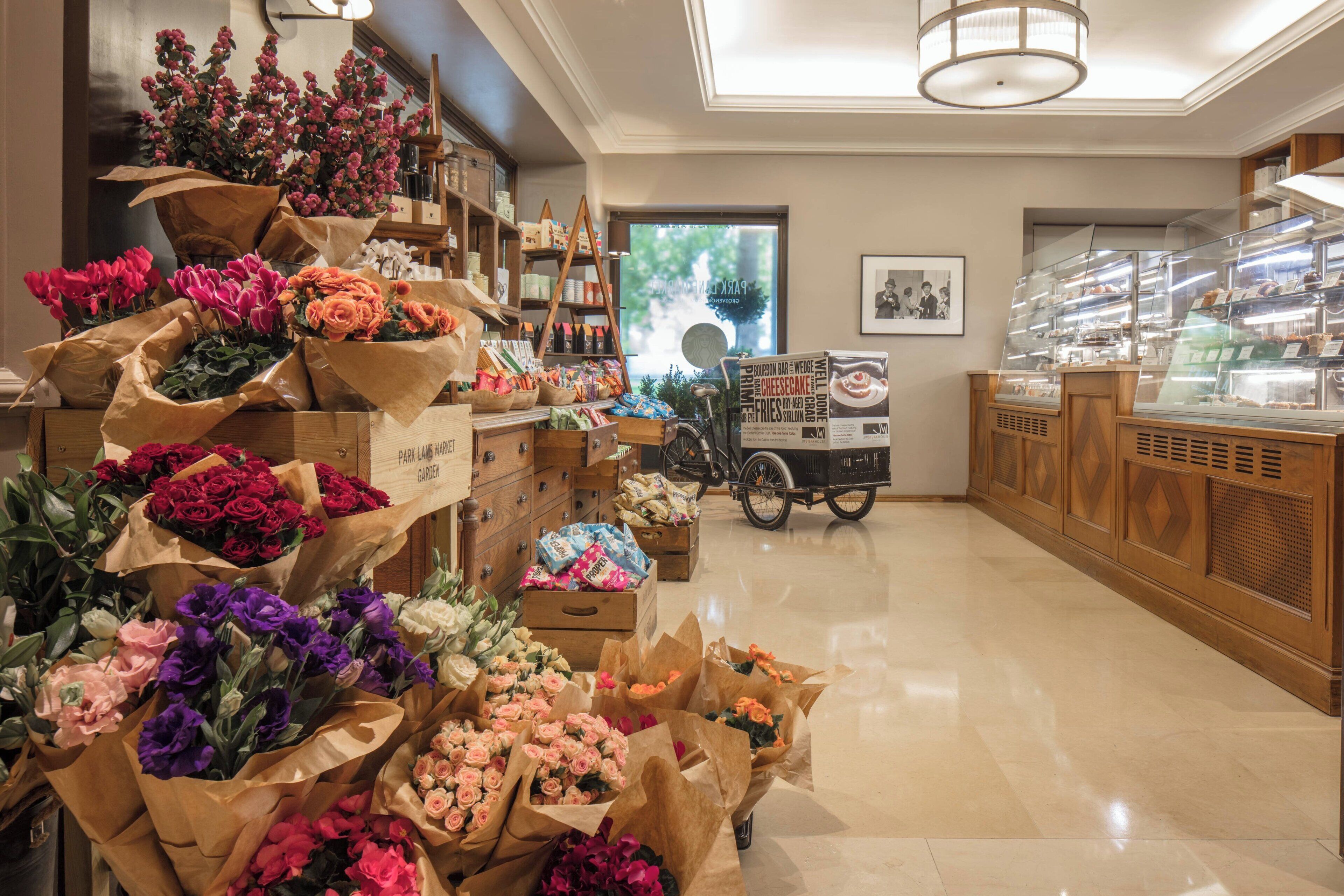 Une boutique de fleurs proposant divers bouquets et une vitrine remplie de pâtisseries.