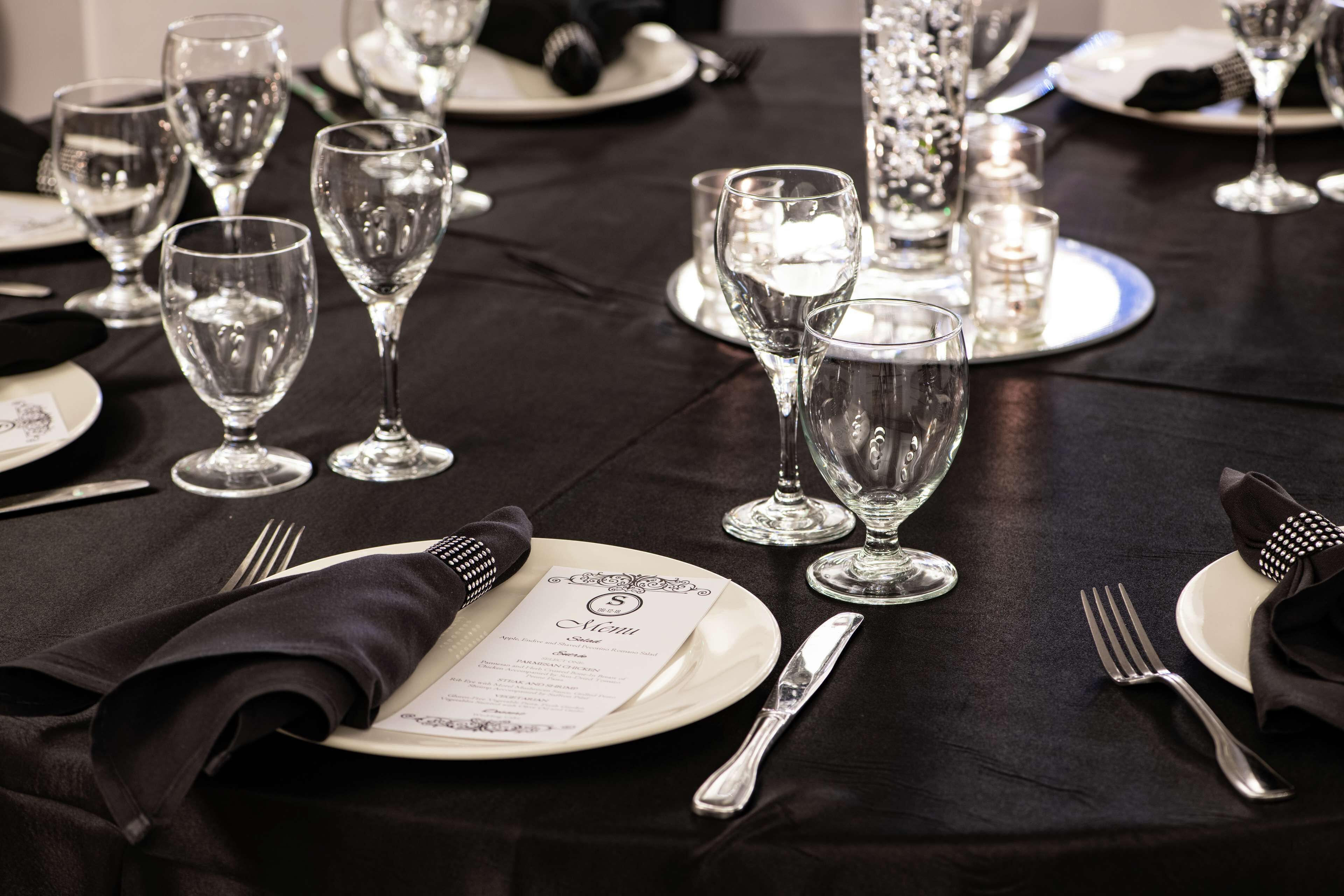 Une table dressée pour un dîner formel, avec de nombreux verres à vin, des assiettes et des couverts.