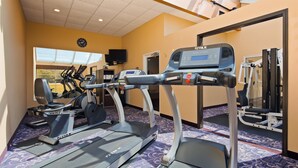A hotel fitness center with treadmills, elliptical machines, and a weight machine. - Best Western Resort Hotel & Conference Center (Portage)