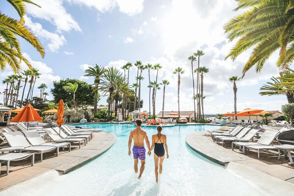 Guests can enjoy a refreshing swim in the resort's pool surrounded by lounge chairs and umbrellas.