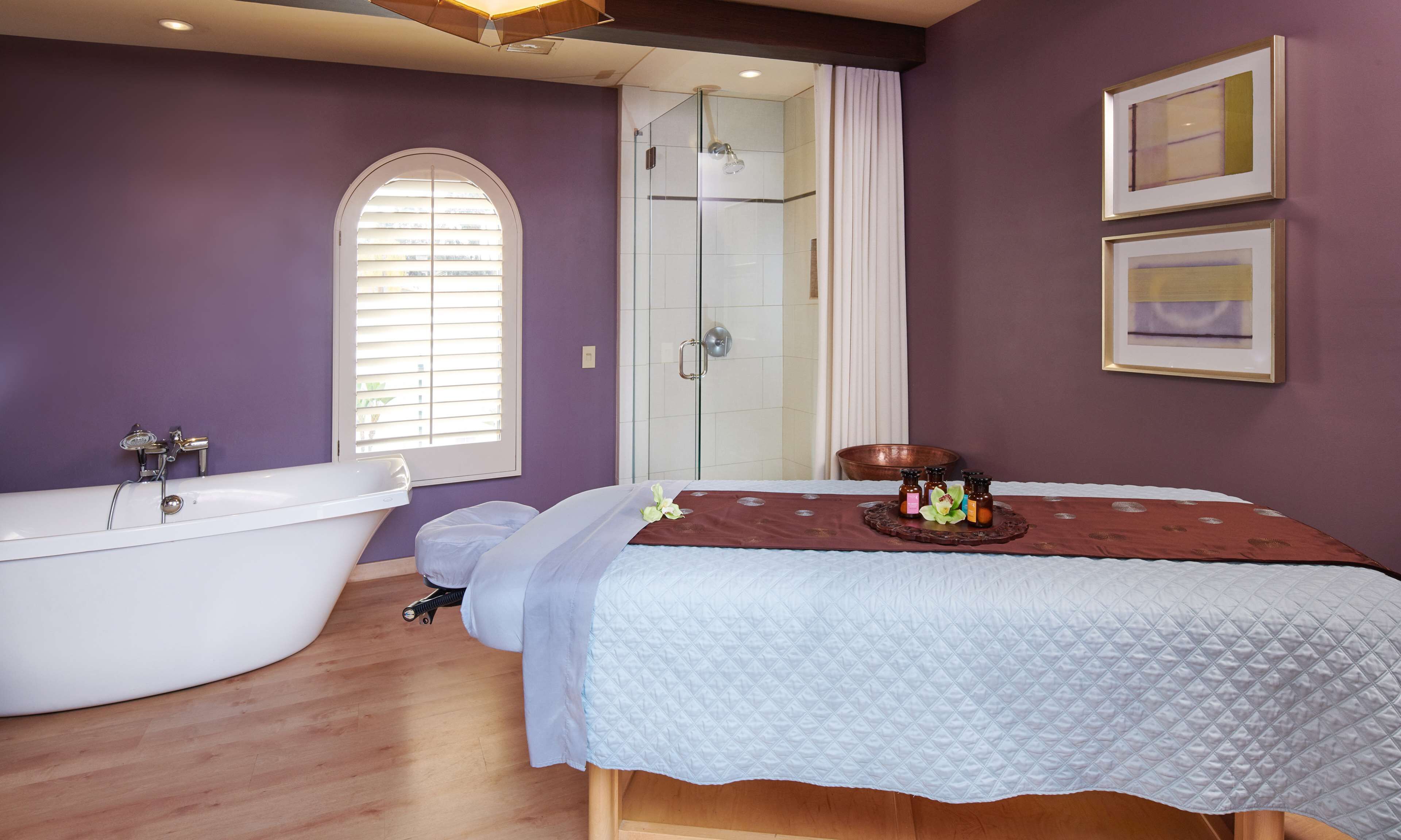 A bathroom with a freestanding bathtub, a shower enclosure, and a vanity with a mirror.