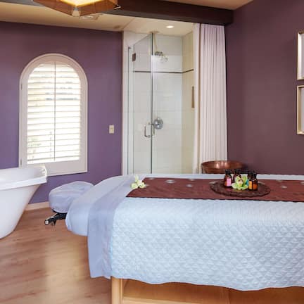 A bathroom with a freestanding bathtub, a shower enclosure, and a vanity with a mirror.