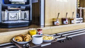 A breakfast setup with croissants, coffee, and juice on a tray. - B&B HOTEL Perpignan Nord (Perpignan)